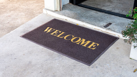 [IMAGE a dark brown mat with yellow letters spell out Welcome]