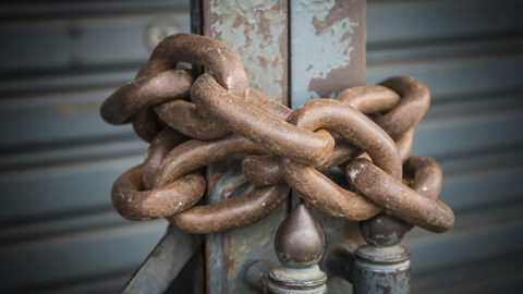 [IMAGE A close up of a heavy rusty chain secures a gate]