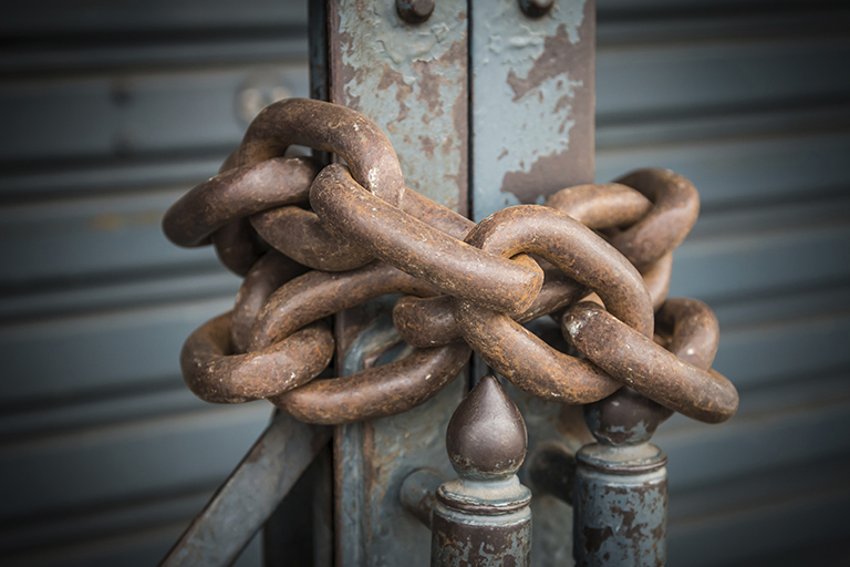 [IMAGE A close up of a heavy rusty chain secures a gate]