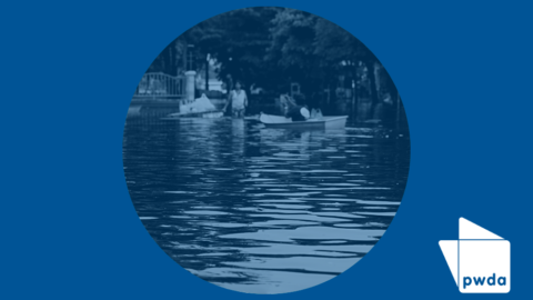 Image of people using boats in floodwater. There is a blue wash over the image the PWDA logo icon in the corner.