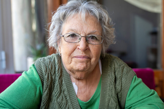 older woman faces the camera directly
