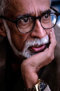 Photo of Suresh Rajan looking pensive with his chin resting on his hand