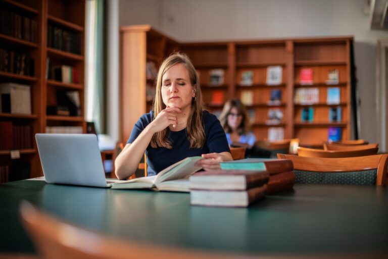 A Visually Impaired Young Woman Sitting And Studying In The Library