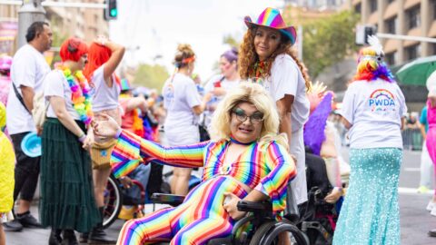 PWDA member at 2024 Mardi Gras wearing a rainbow jumpsuit