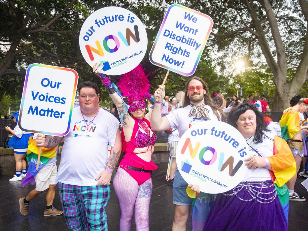 A group of people at the 2024 Mardi Gras parade holding up signs