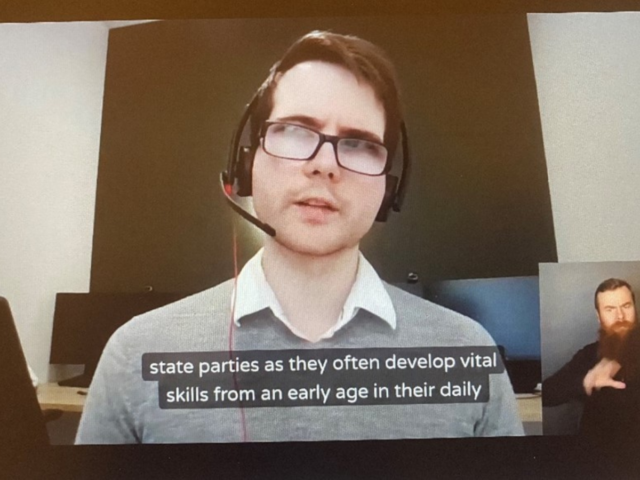Alex Ladd (Caxton Legal Centre) appears on a computer screen, delivering his closing remarks. Alex is wearing a white collared shirt, grey jumper, glasses and a headset. A sign-language interpreter appears in the bottom right corner of the screen.