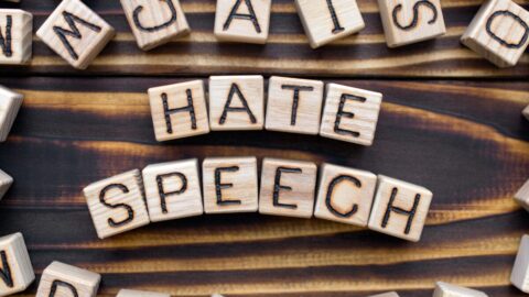 Letter blocks of wood spell out the words Hate Speech