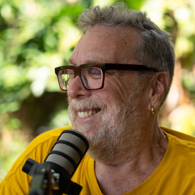 Uncle Paul Constable-Calcott with a microphone and wearing a yellow tshirt and