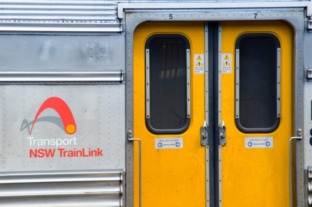 The yellow train door with Transport nsw Trainlink logo in close up, at Central railway station.