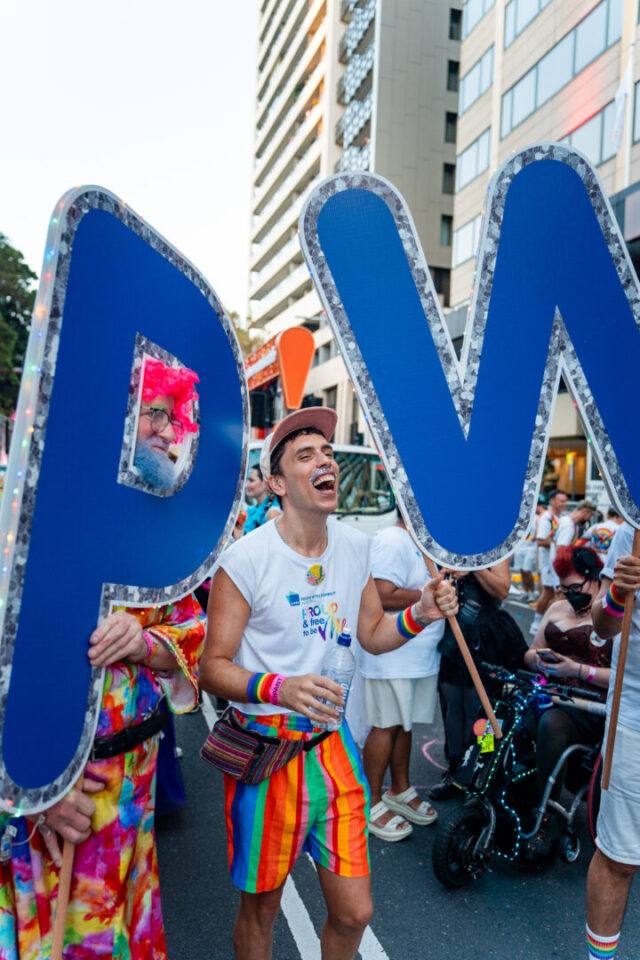 PWDA staff cheer holding PW signs.