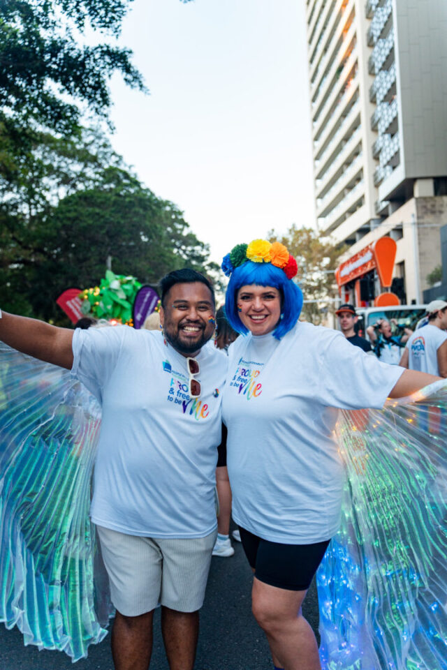 Giancarlo and Anastasia pose with wings held out behind them smiling at camera. 