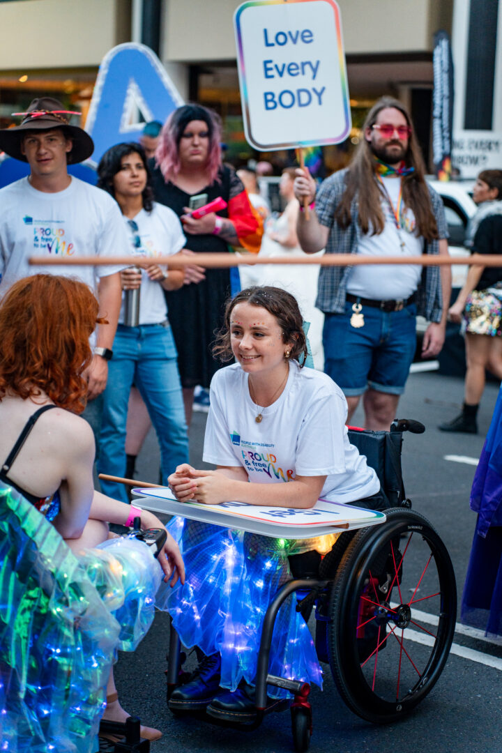 PWDA member Caitlin speaks to PWDA President Trinity in marshalling area of 2025 Mardi Gras 