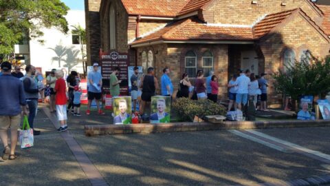 People lining up outside a church to vote in an election