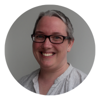 Anna Burke Circle - People with Disability Australia Photo of Anna Burke, Anna is smiling at the camera and is wearing a white/grey shirt and glasses with black frames.