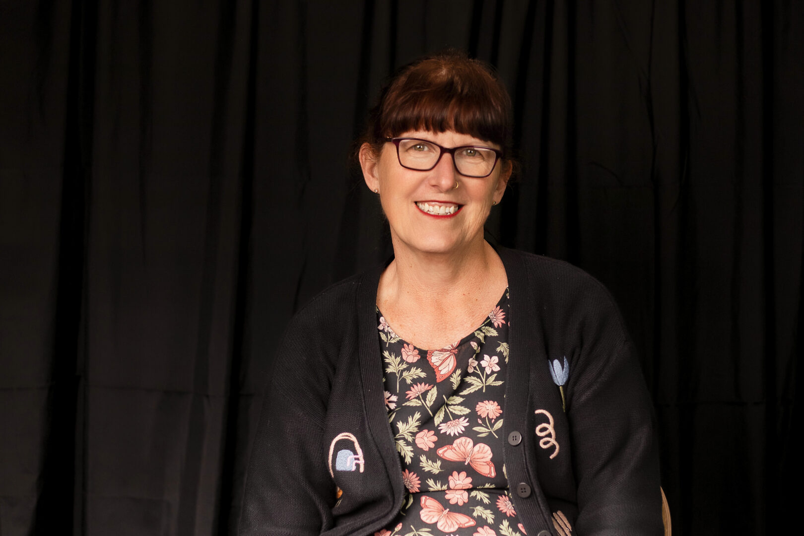 HJ_3 - People with Disability Australia Hollee James wearing a black cardigan and colourful dress