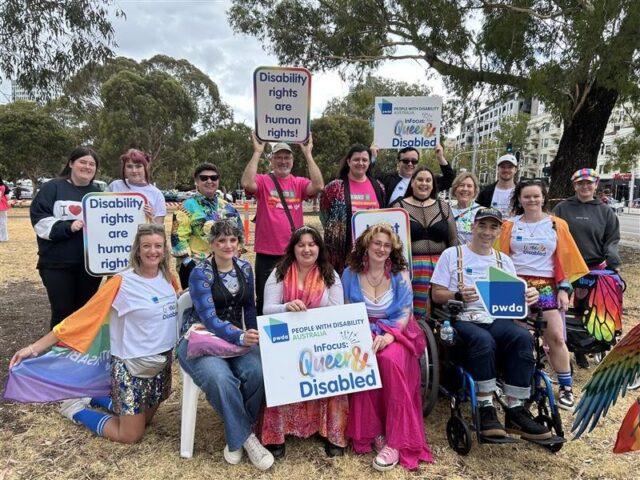 PWDA members at the 2026 Midsumma Pride March. The group is posing together for a photo with disability rights signs. 