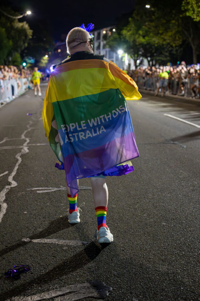 PWDA participant wearing PWDA flag/cape at Mardi Gras 2026