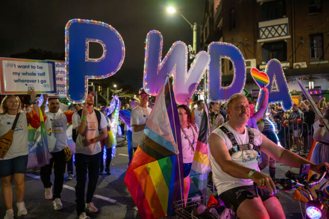 PWDA participants marching at Mardi Gras 2026 with PWDA letters