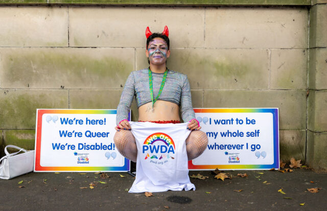 PWDA participant waiting with signs at Mardi Gras 2026