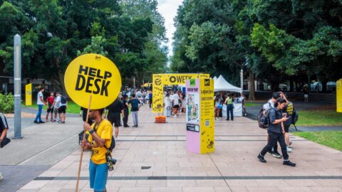 student holding a sign offering assistance to visitors on University of New South Wales (UNSW)